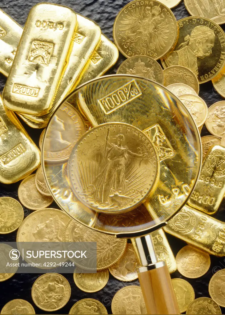 Magnifying glass over gold coins