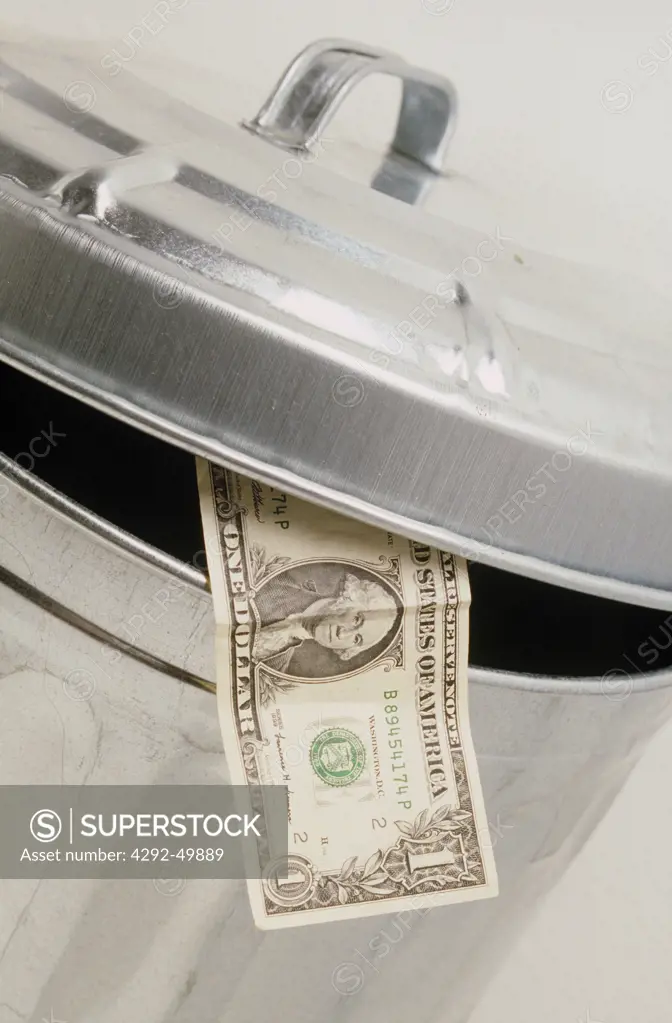 Dollar in trash container