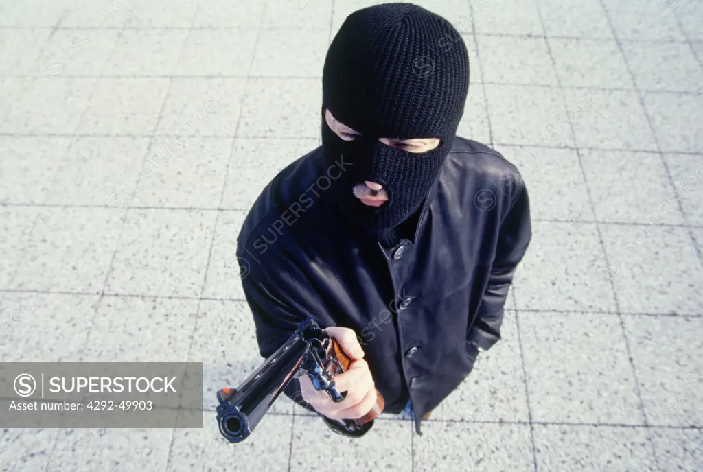 Man wearing balaclava holding a gun