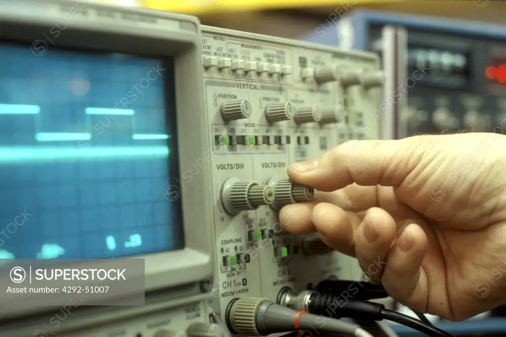 Hand of engineer on oscilloscope