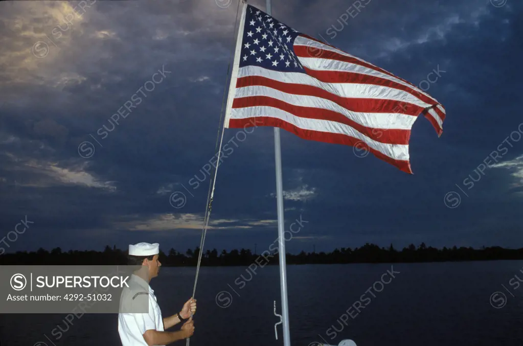 USA, Hawaii: US Naval soldier hoisting american flag at Pearl Harbor