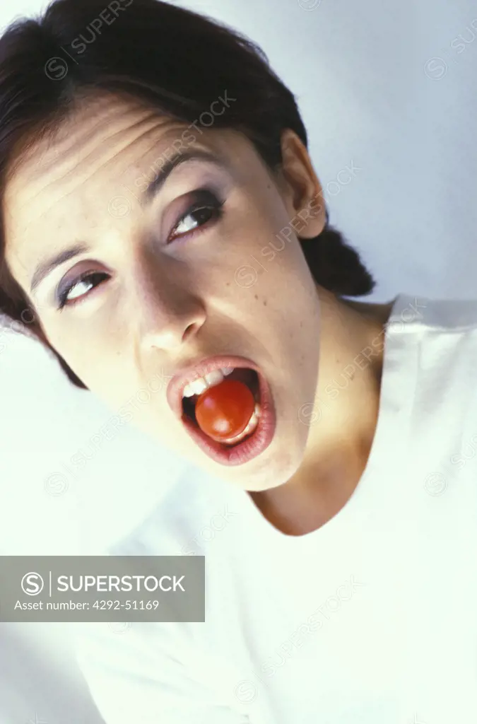 woman with a cherry tomato in her mouth