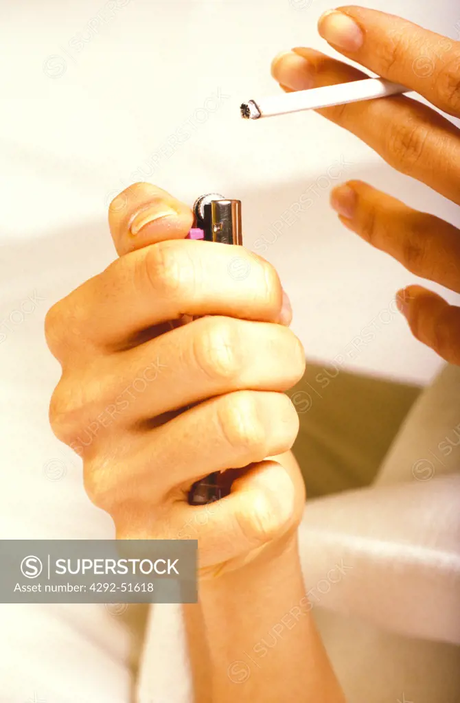 Close up of hands with lighter and slim cigarette