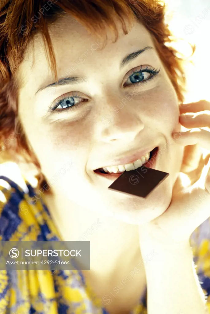Red hair woman eating chocolate