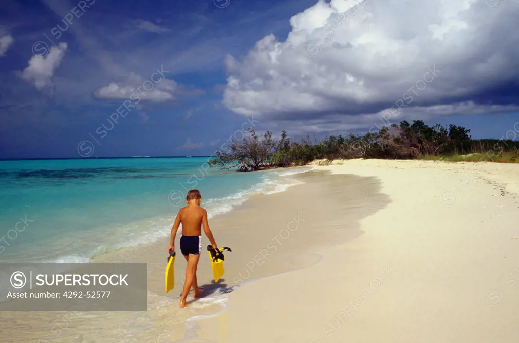 Boy walking on tropical beach