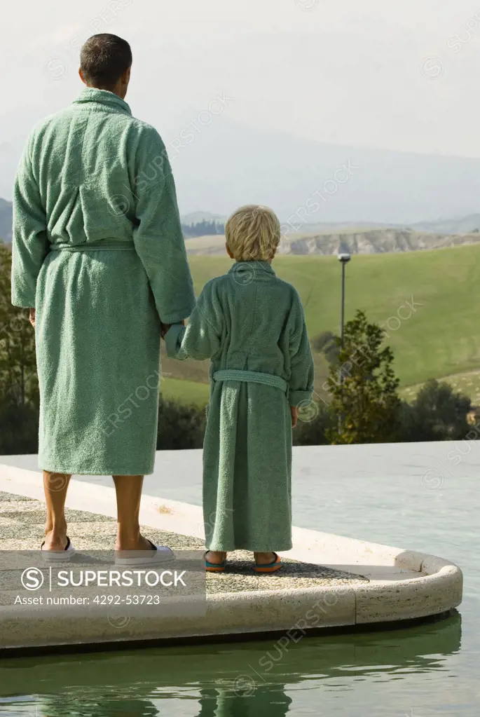 Italy, Tuscany, San Casciano dei Bagni,Young man with his child in the thermal swiimingpool