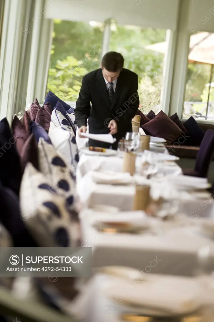 Waiter setting the tables for dinner at Lake House Hotel in Daylesford, Australia