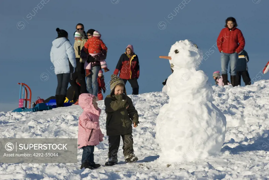 Austria, Carinthia, Villach, Dobratsch Natural Park, Children playing a snowman
