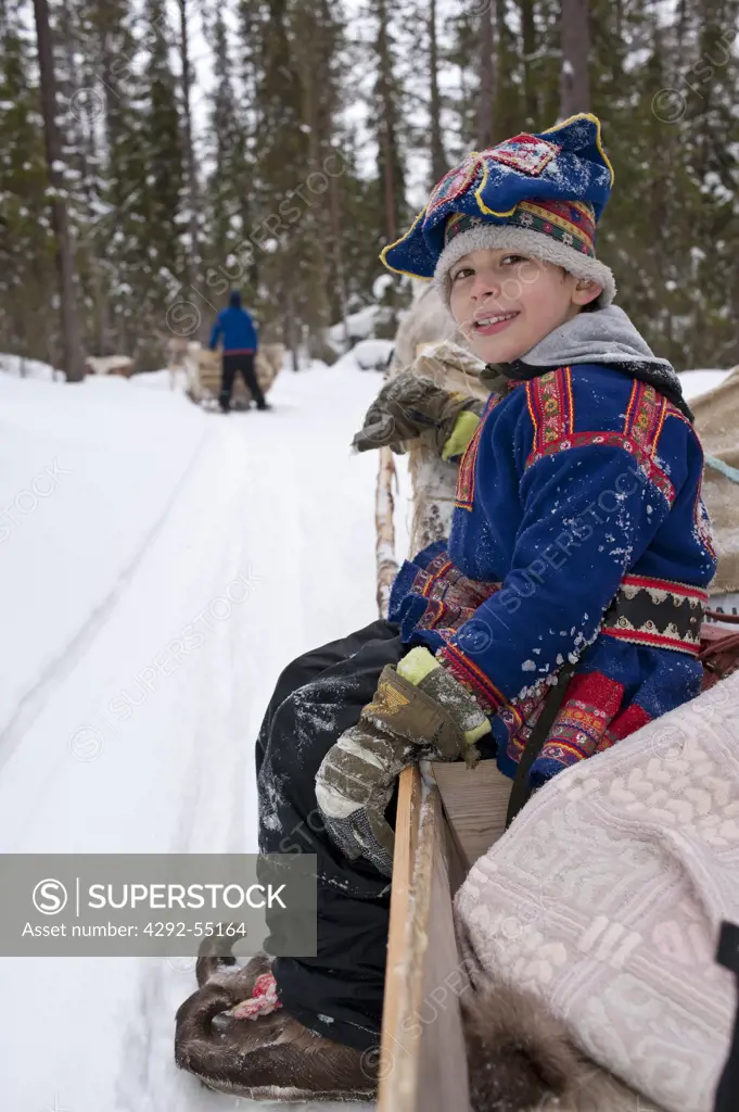 Finland, Lapland, Venejarvi village. Boy's portrait on reindeer sleigh