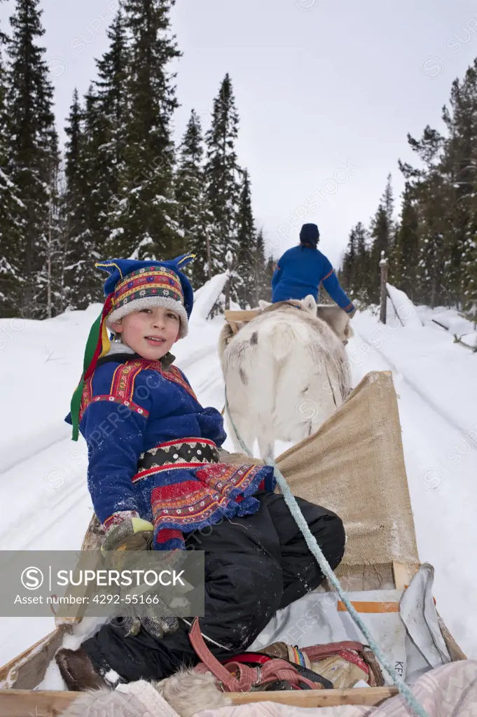 Finland, Lapland, Venejarvi village. Boy's portrait on reindeer sleigh