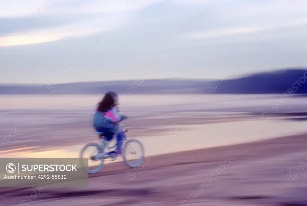 Girl cycling on beach