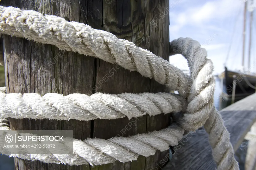 A ship's bow line tied to a piling at a dock in Boothbay Harbor, Maine.
