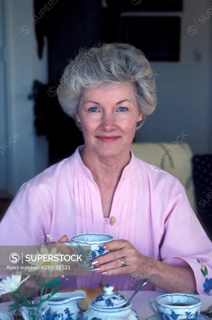 Portrait of mature woman at home having breakfast