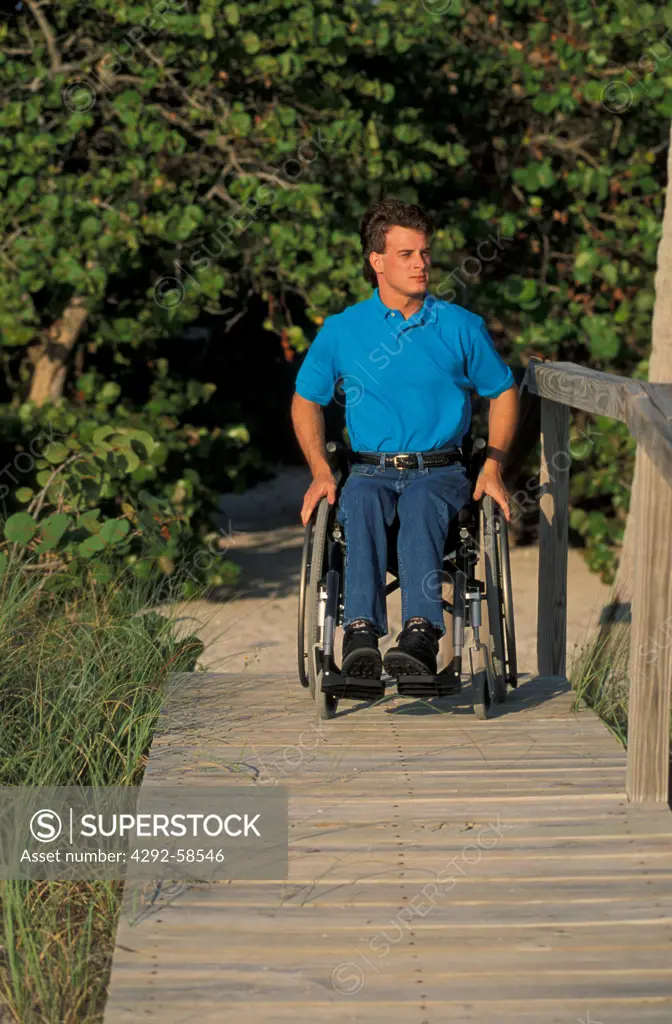 Disabled man in wheelchair using ramp