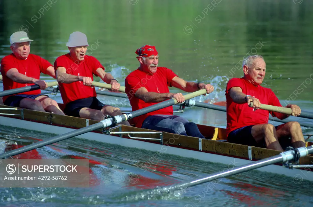 Senior men rowing team exercising in boat