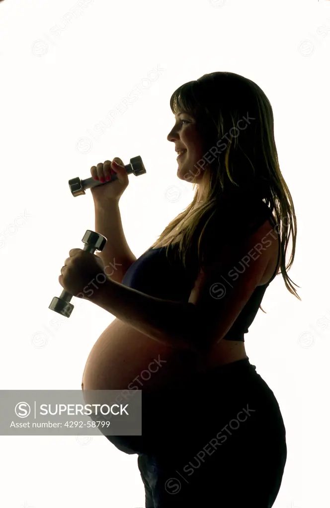Pregnant woman exercising with dumbbell