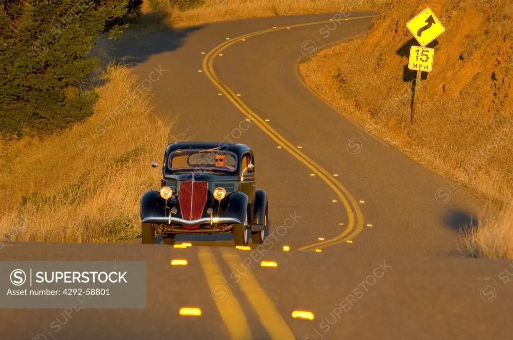 Automobile 1936 Ford coupe on winding road in Northern California