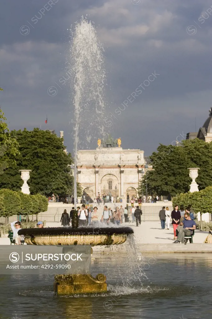 Fountain and Arc de Triomphe du Carrousel at Jardin des Tuileries sculpture garden with the Musee du Louvre in back, Paris, France