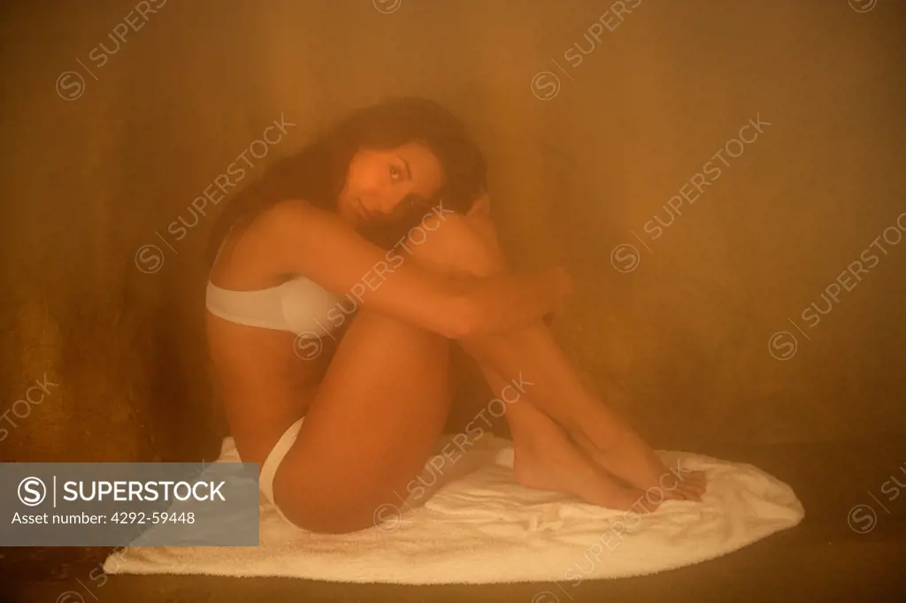 Young woman sitting in sauna