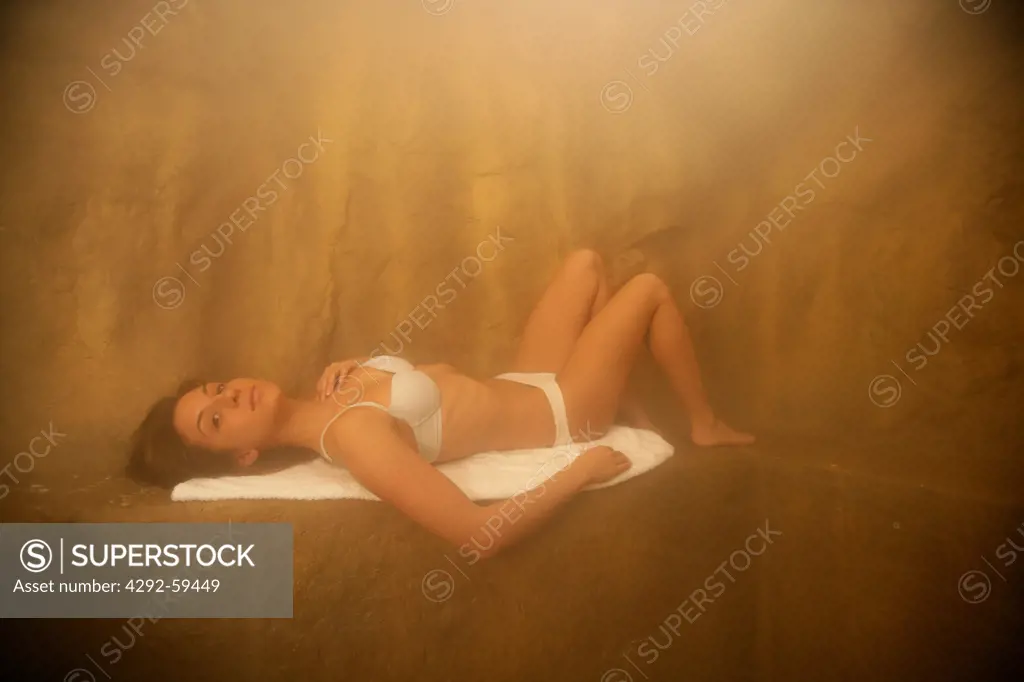 Young woman lying in sauna