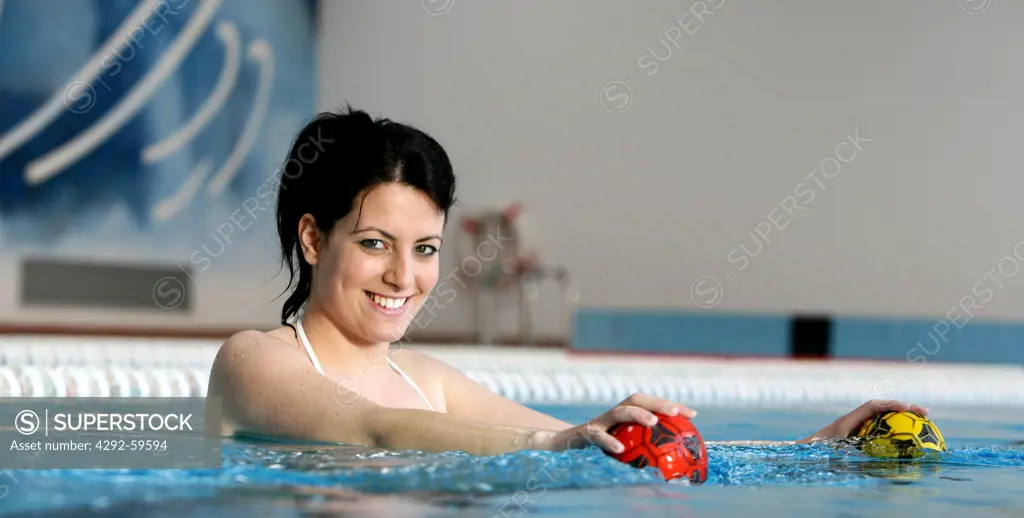 Woman in swimming pool doing pilates exercise