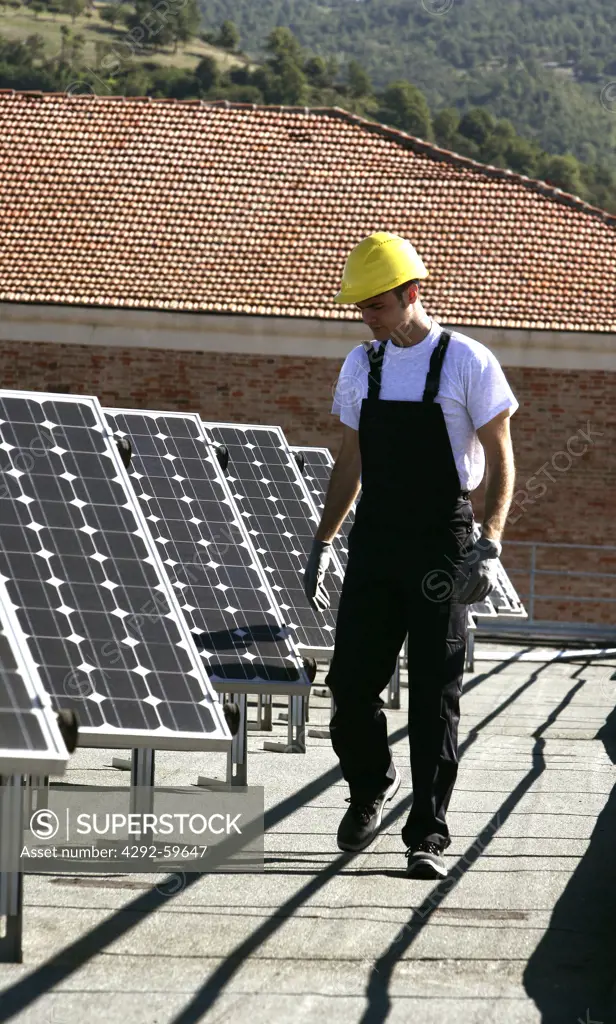 Worker walking by solar panels