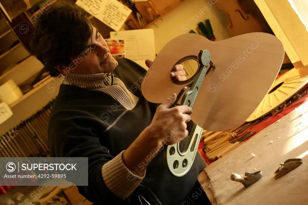 Craftsman making guitar