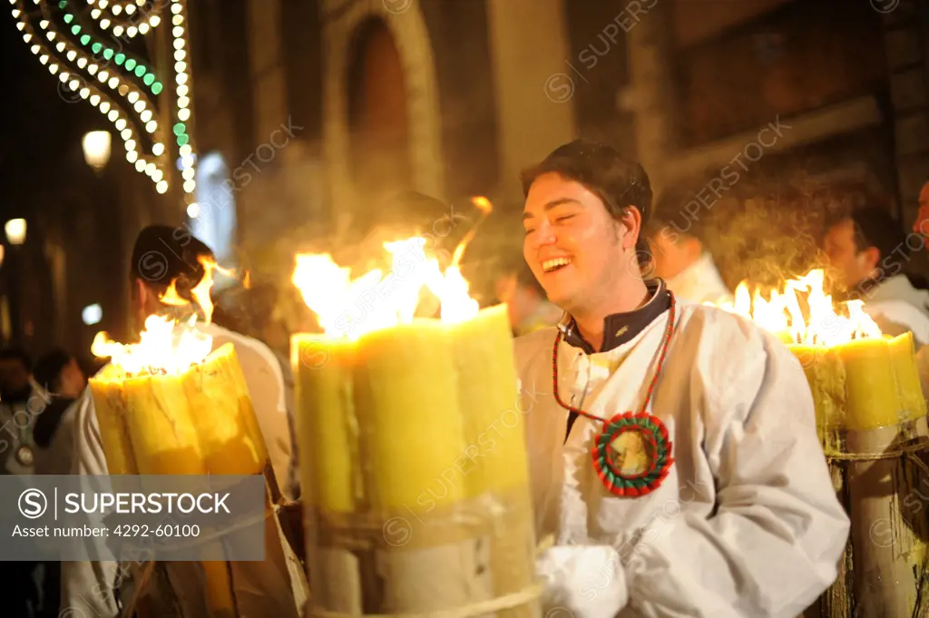 Italy, Sicily, Catania, men carrying  with candles during Sant'Agata Feast (the Patron Saint of the city)