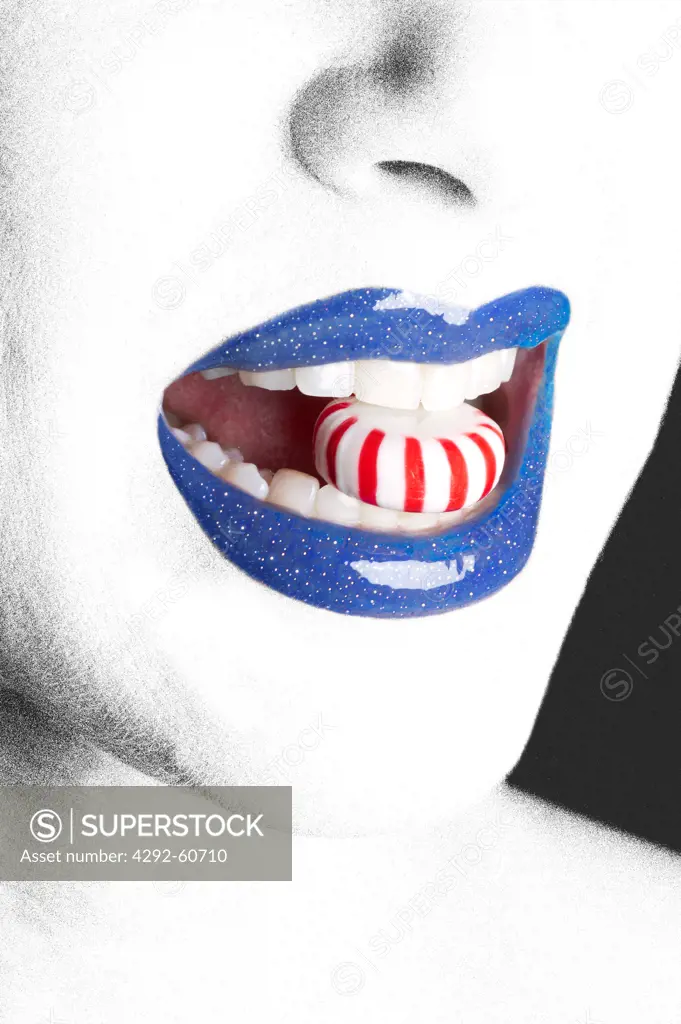 Woman with blue lips and candy in her mouth
