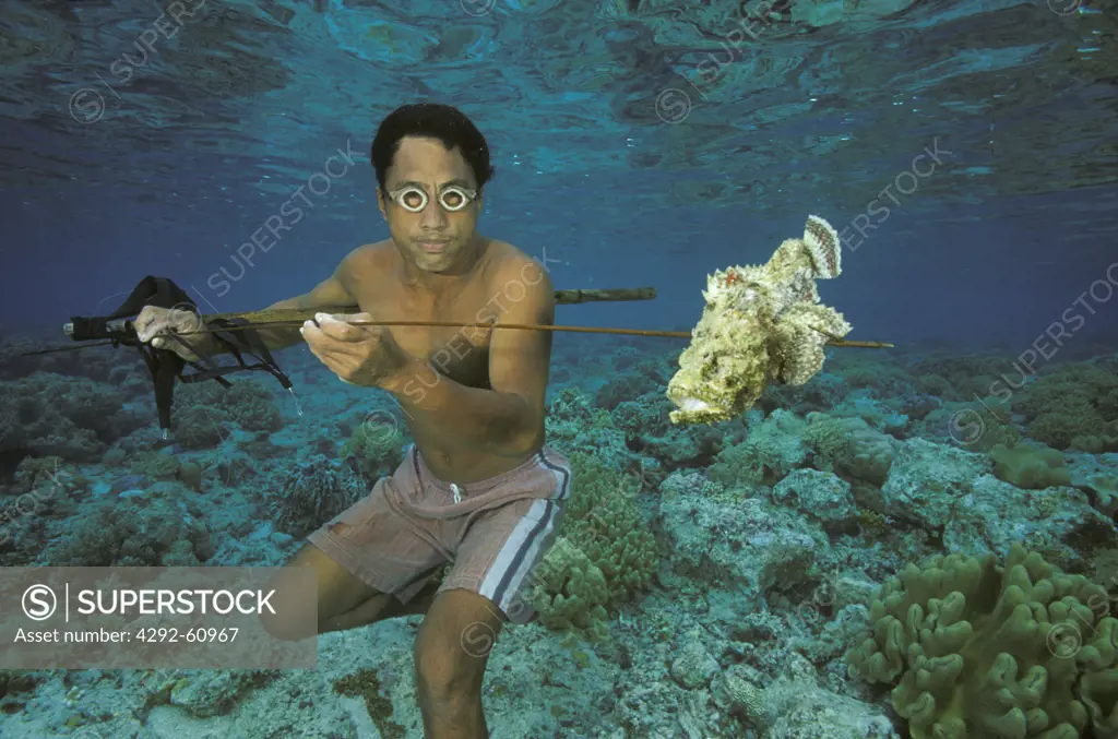 Fisherman with stone fish on spear. Bunaken, Sulawesi, Indonesia