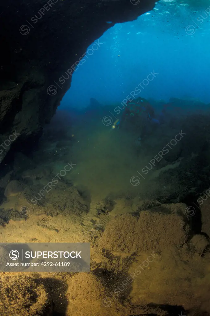 Italy, Aeolian Islands, Vulcano island, diver exploring cave