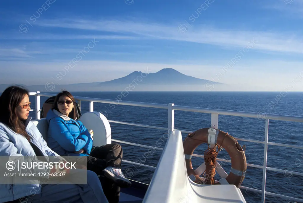 Europe, Italy, Bay of Naples, asian girls going to Capri in winter time, Vesuvius on horizon