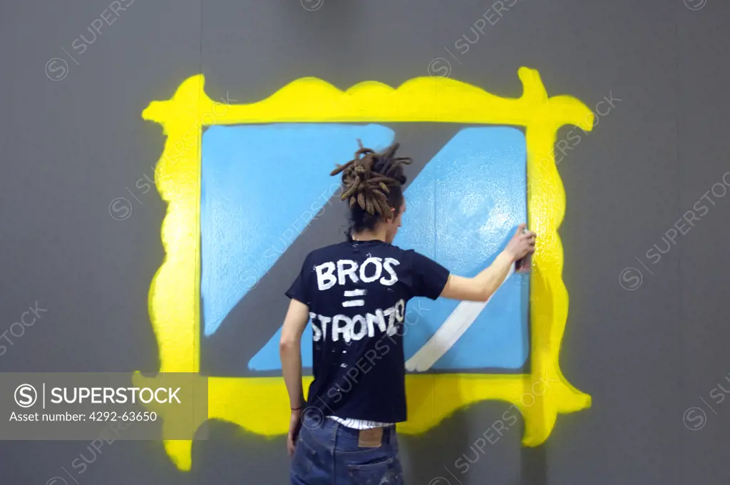Teenage boy spray painting on wall