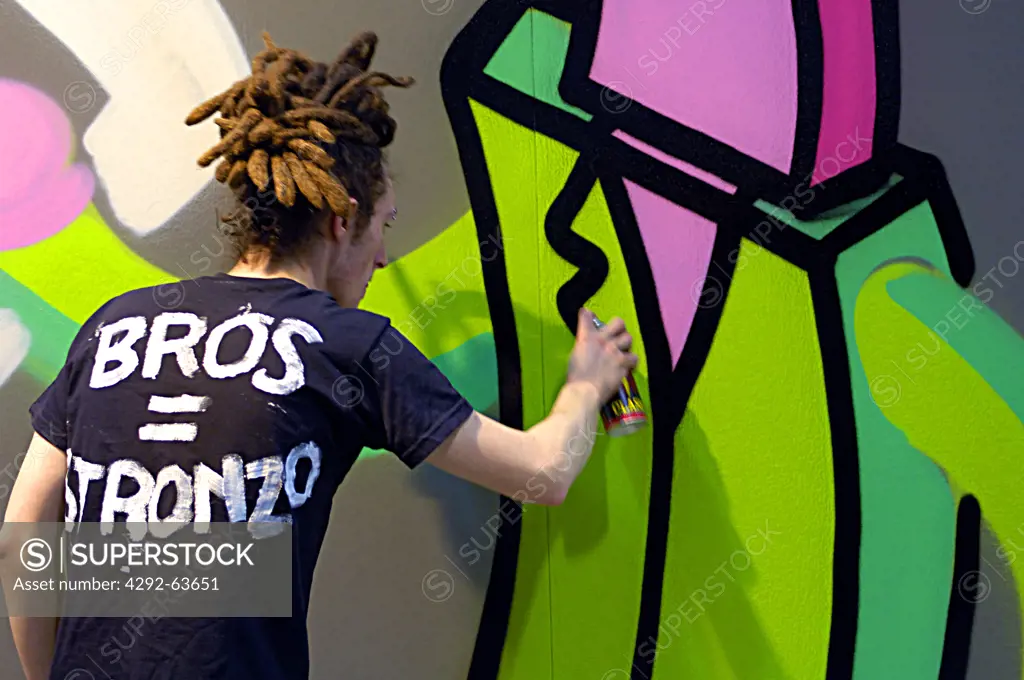 Teenage boy spray painting on wall