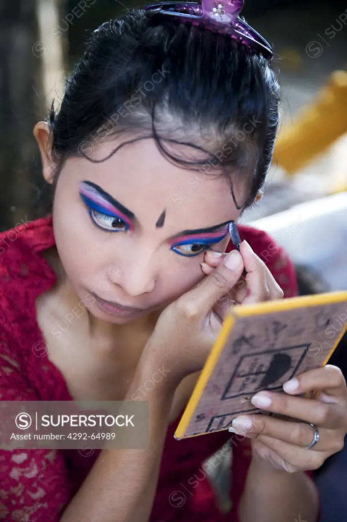 Indonesia, Bali, Balinese dancer applying make up