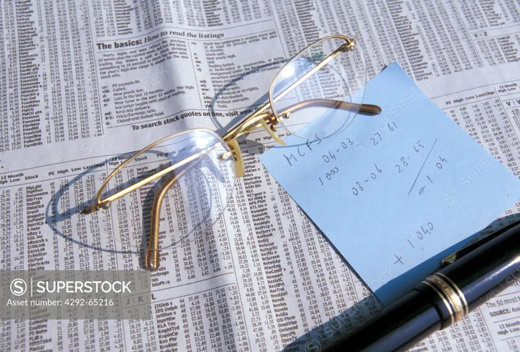 Eye-glasses and notes on stock market investment table