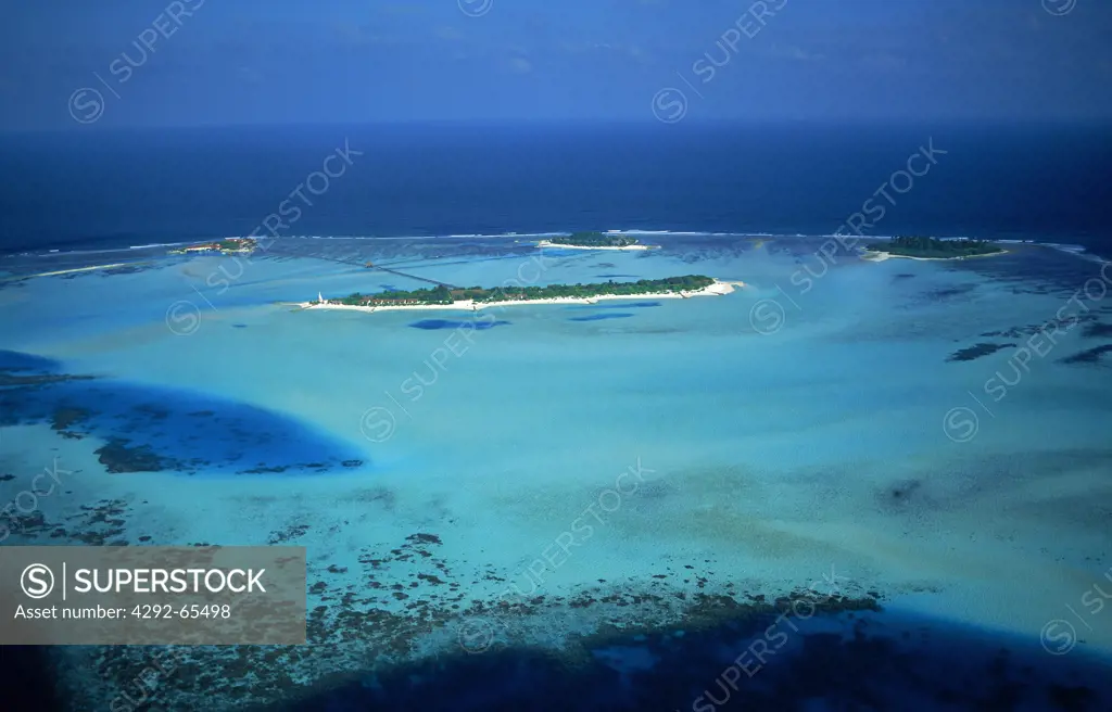 Aerial view of resort island encircled by reef and blue Indian Ocean in the Maldive Islands, in the Ari Atoll