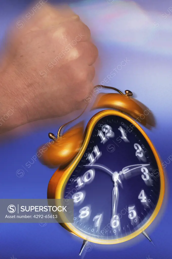 Fist of a man on hitting an alarm clock
