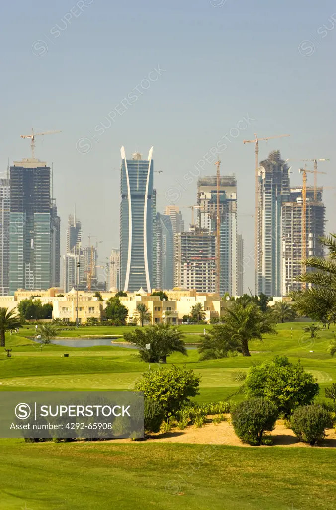 United Arab Emirates, Dubai, Skyline of Emirates Lakes Towers overlooks the Montgomerie Golf Course at Emirates Hills, Villa developments.