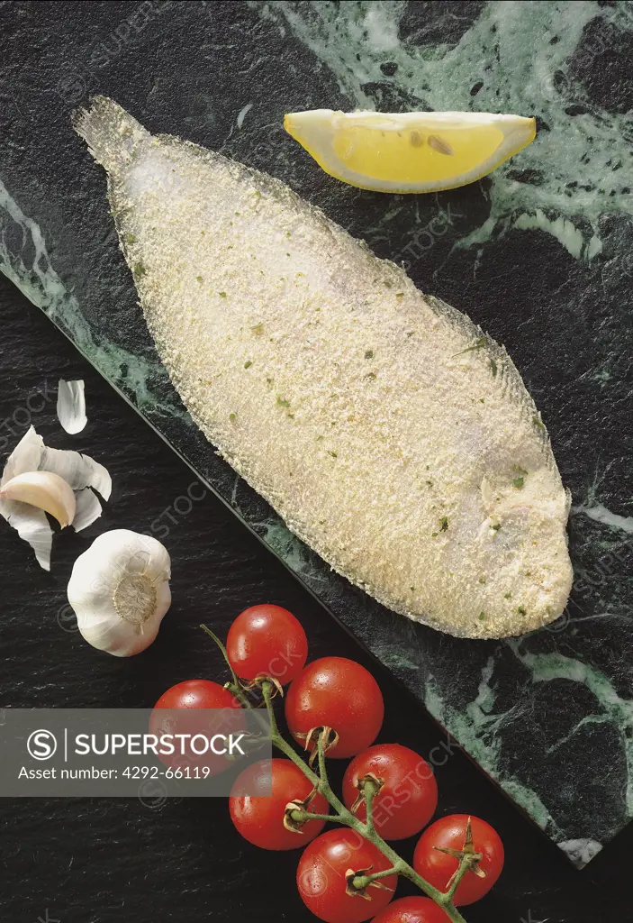 Deep pan sole on stone with garlic and cherry tomatoes