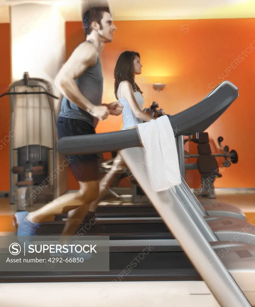 Man and woman exercising on treadmill