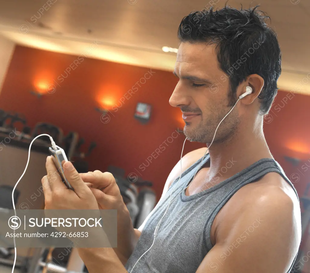 in gym listening to music with mp3 player while exercising