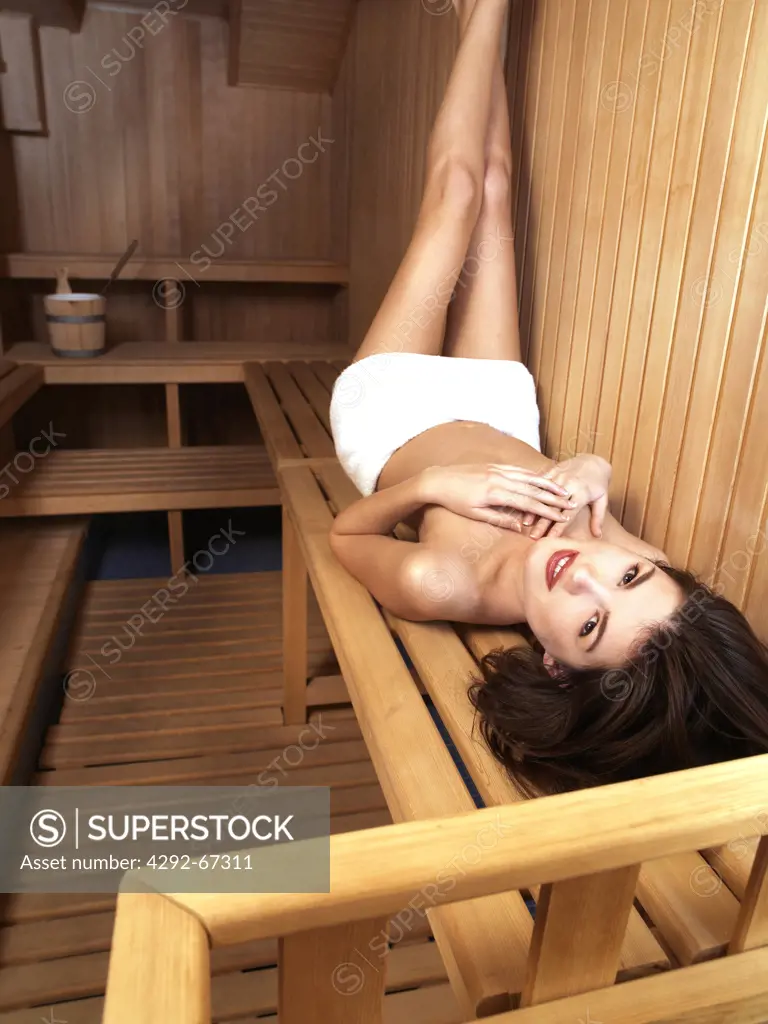 Young woman lying down in sauna