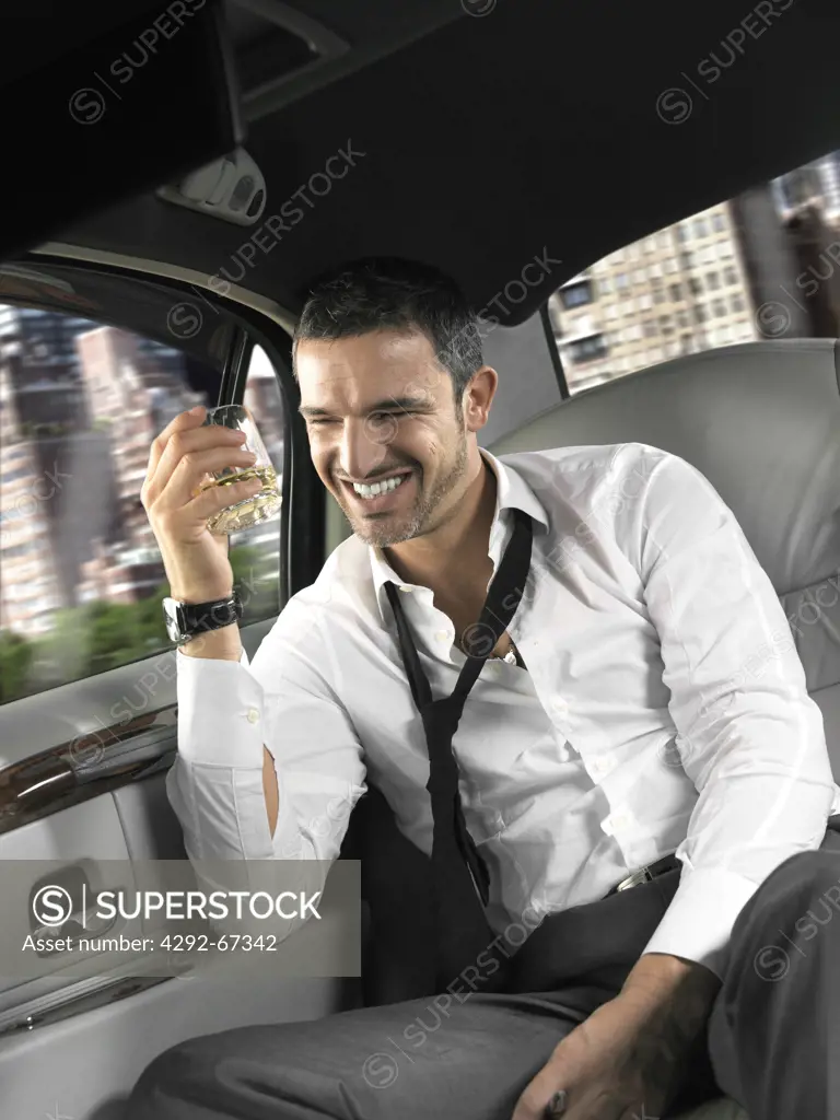 Businessman sitting in the back seat of a limousine