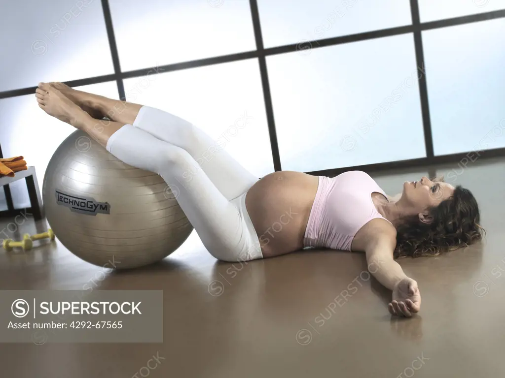 Pregnant woman sitting exercising with fitness ball