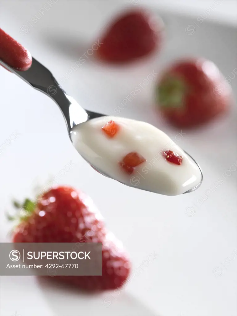 Spoon of yoghurt with strawberries