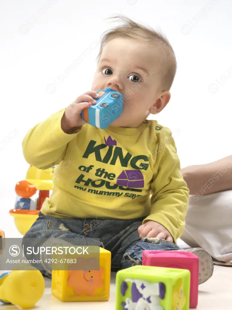 Studio shot of a baby boy with toys