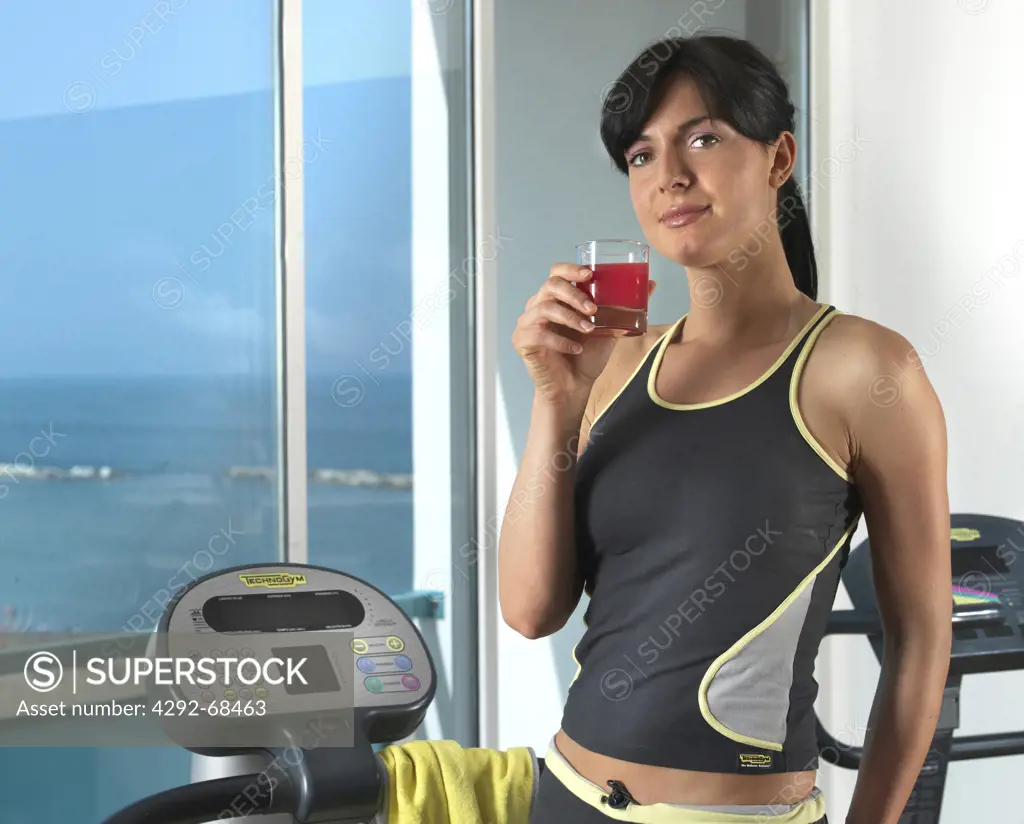 Woman at gym with glass of juice