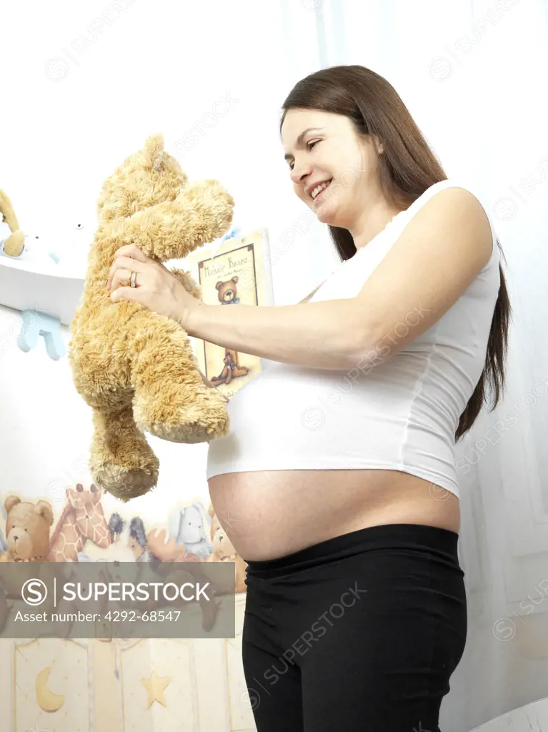 Pregnant woman holding teddy bear