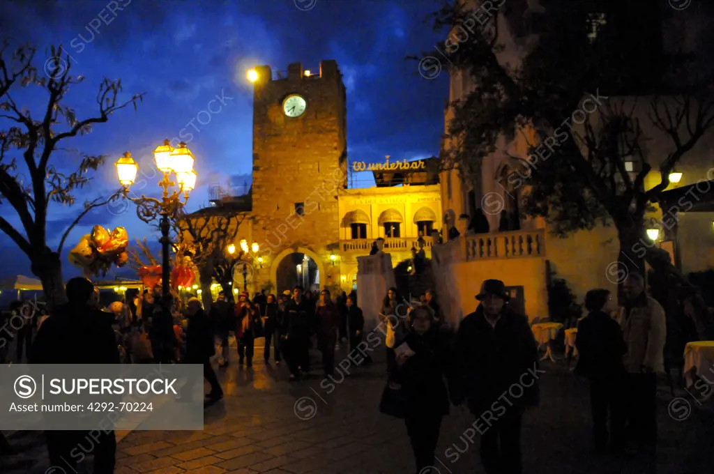 Italy, Sicily, Taormina. IX Aprile Square, Porta di Mezzo, clock tower at night.